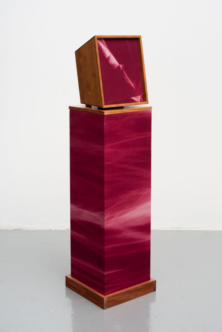 SOUND IN TIME (FALL), 2023, Sun and time on maroon fabric, thread, African mahogany, speaker, amp, sound piece, power cord, 12 1/2 x 15 x 11 inches, 31.8 x 38.1 x 27.9 cm, (with pedestal - 55.75 x 14.75 x 13.75 inches)
