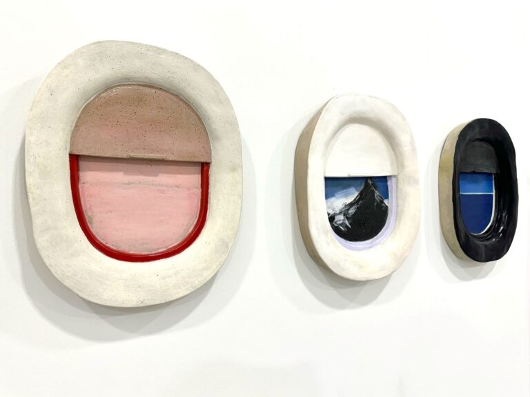 An installation of CJ Chueca's ceramic "airplane window" sculptures.